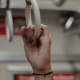 電車のつり革につかまる男性