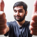 親指を立てて笑顔を見せる男性