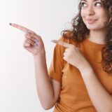 指をさして話のポイントを示す女性