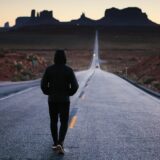 夕日に向かって歩き去る人