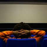映画館で映画を見る男性