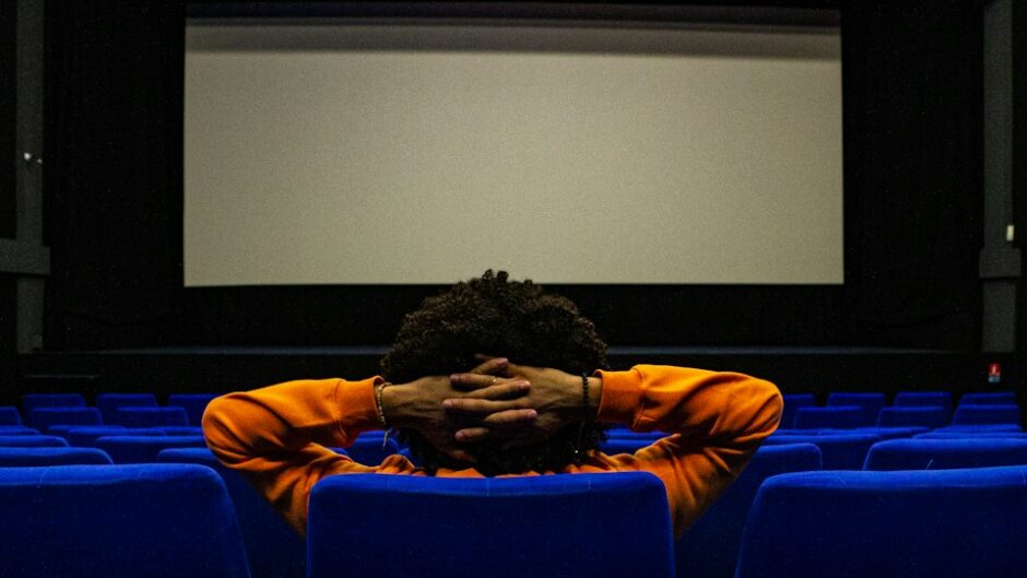 映画館で映画を見る男性