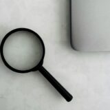 ノートPCの横に置かれた虫眼鏡
