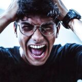 頭を抱えて声を上げる男性