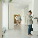 オフィスの廊下で話しながら歩く人々