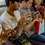電車でスマホを見る人々
