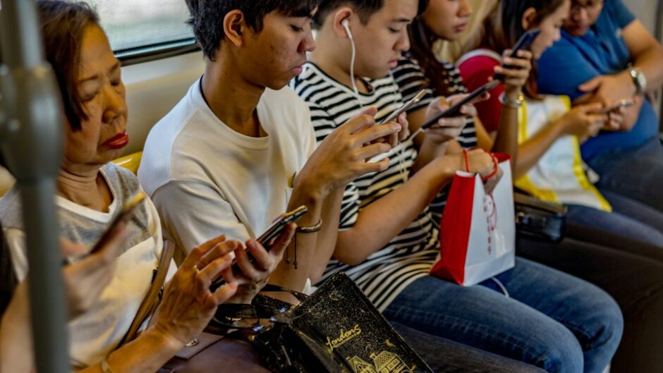 電車でスマホを見る人々