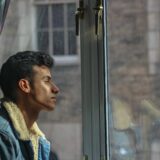 窓の外を見つめる男性