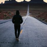 夕日に向かって歩いていく人