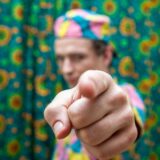 カメラに向かって指を差す男性