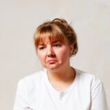 疑わしそうな表情を浮かべる女性