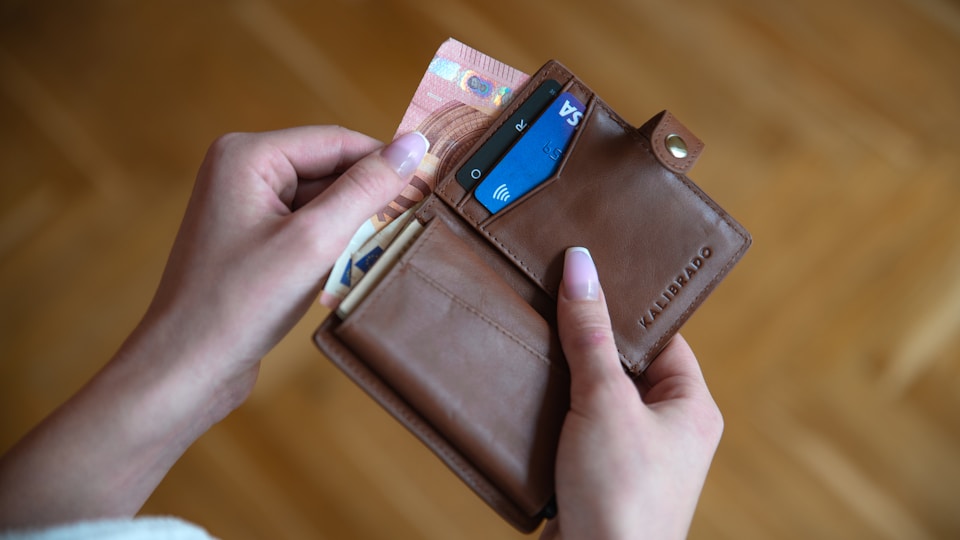財布からお金を出そうとする手