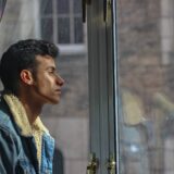 窓の外を眺める男性
