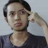 考え込むアジア人男性