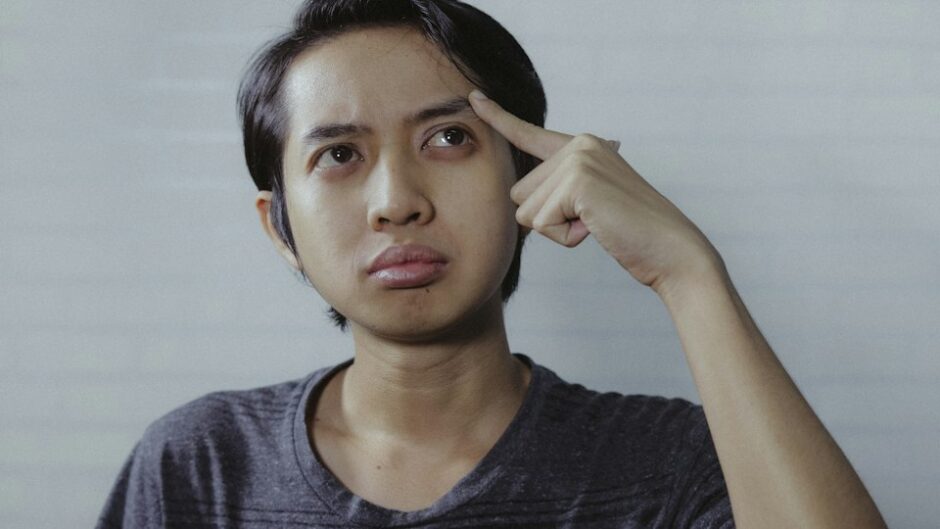 考え込むアジア人男性