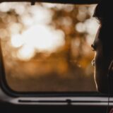 車内で窓辺に座り外を眺める人