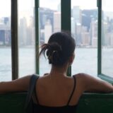 窓辺から街並みを眺める女性