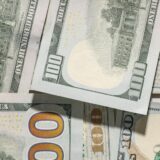 机の上に散らばった100ドル札