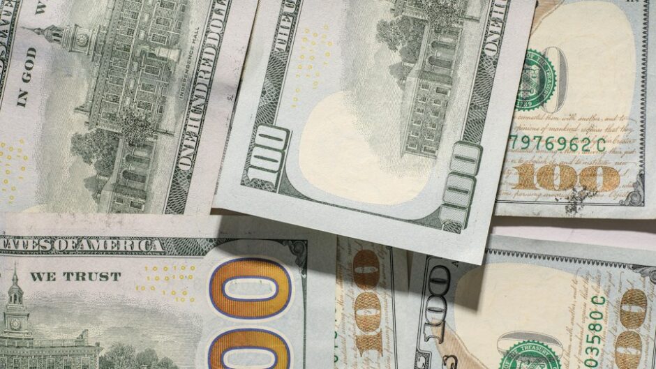 机の上に散らばった100ドル札
