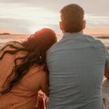 夕暮れの浜辺を歩くカップル