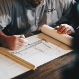 設計図に向かって作業する建築家