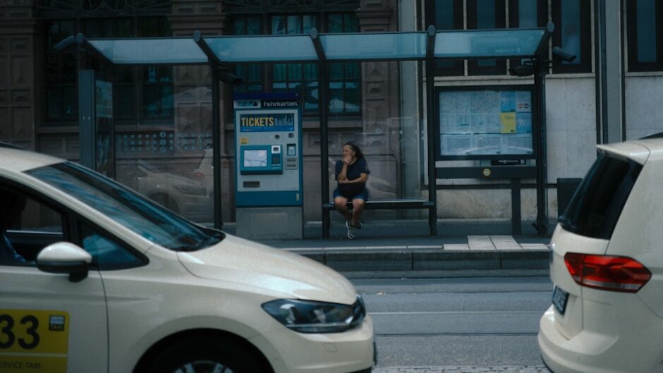 街のバス停でバスを待つ女性