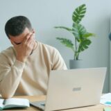 パソコンの前で頭を抱える男性
