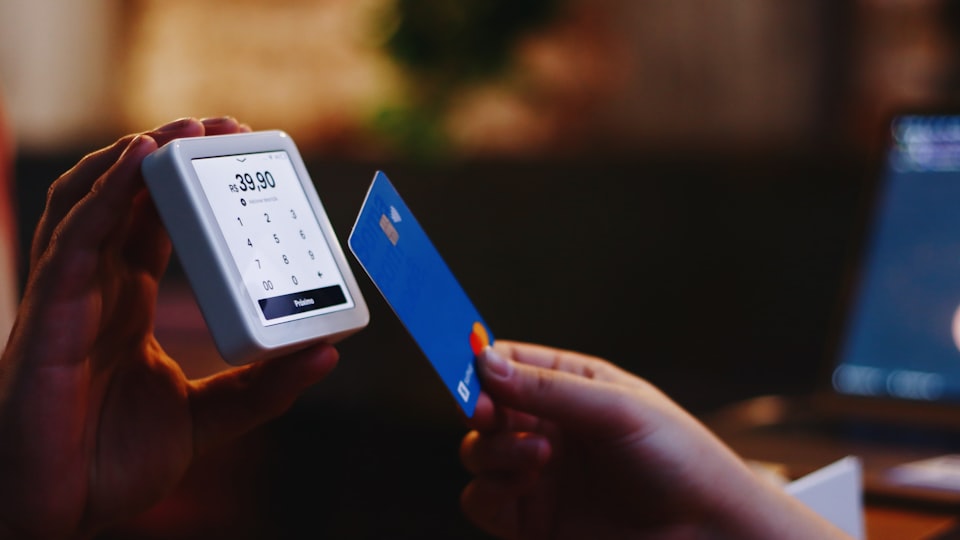 クレジットカードとスマホを手にする人