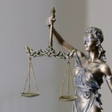 天秤を持つ正義の女神像（until proven otherwiseのイメージ）