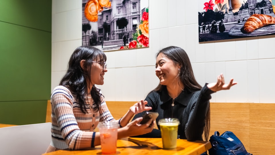 カフェのテーブルで会話する2人の女性