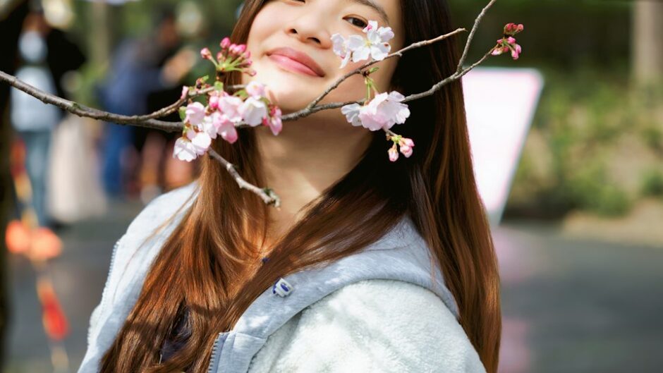 満開の桜の下で微笑む女性