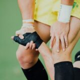 転んだ人に手を貸して立たせる男性
