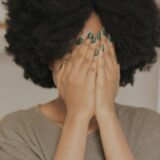両手で顔を覆う女性