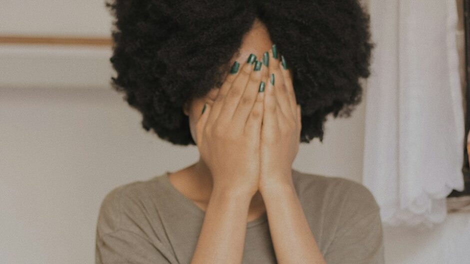 両手で顔を覆う女性