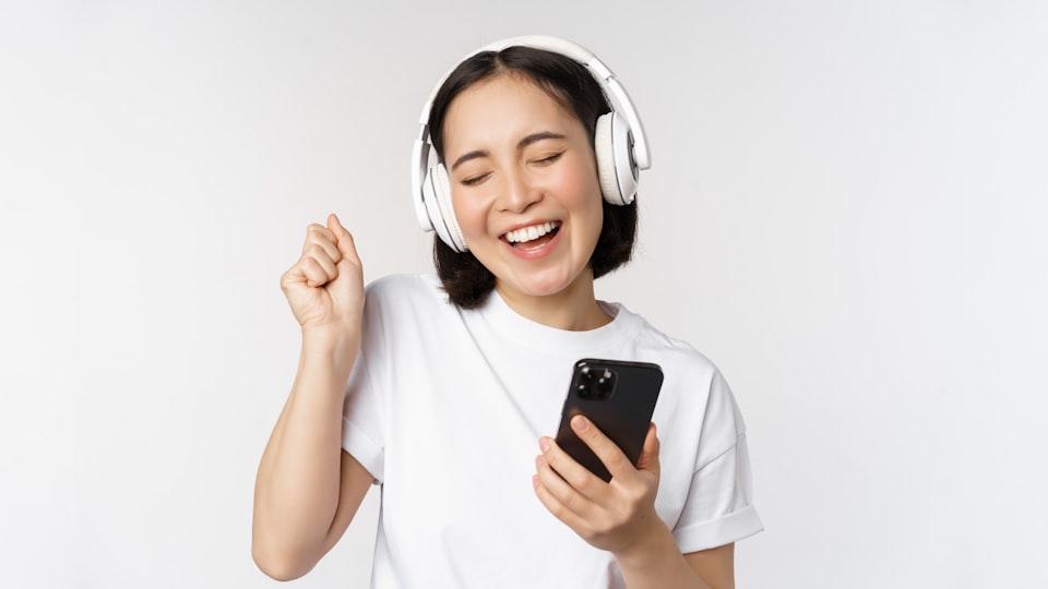 ヘッドホンとスマホを持つ女性