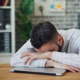 デスクで頭を抱える男性 - バーンアウトのイメージ