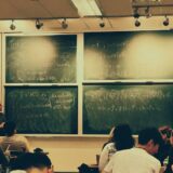 students sitting in front of a chalkboard