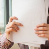 書類に囲まれて困る人