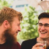友人同士がビールを飲みながら冗談を言い合うシーン