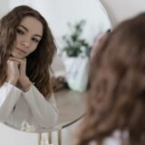新しいヘアスタイルで鏡を見る女性