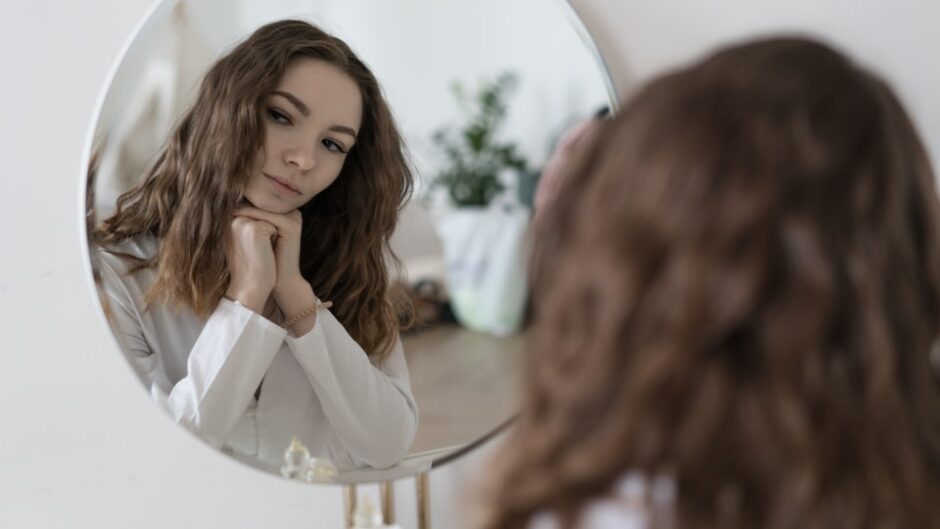 新しいヘアスタイルで鏡を見る女性