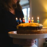 誕生日ケーキの前で微笑む女性