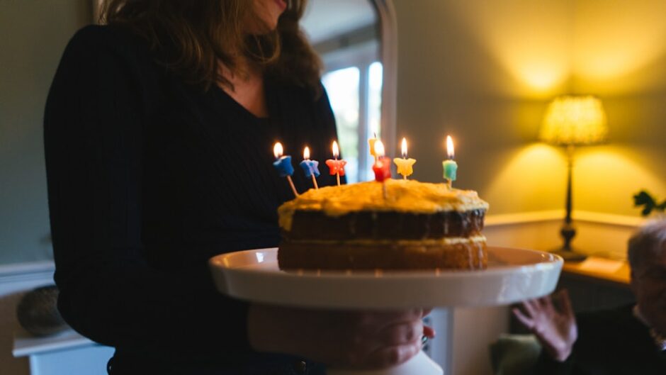 誕生日ケーキの前で微笑む女性