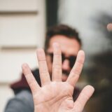 man raising his hand to say stop