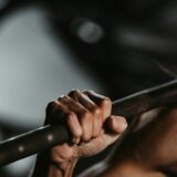 woman lifting a barbell, trying hard