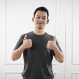自信を持ってサムズアップする人のイメージ