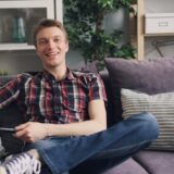 ソファでリモコンを握る男性