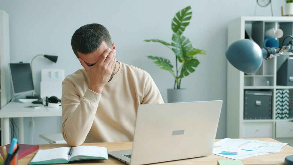 頭を抱えて疲れた様子の男性