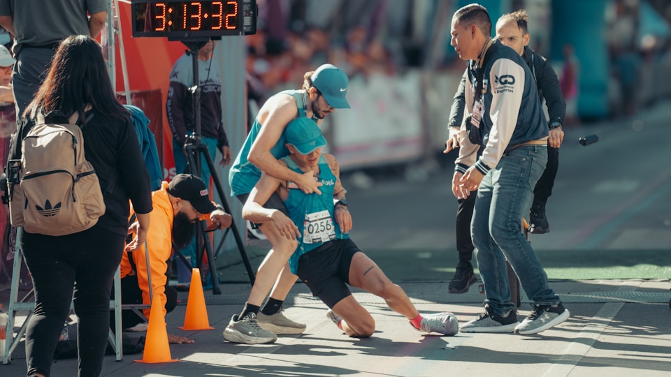 ゴールで支えられるランナー