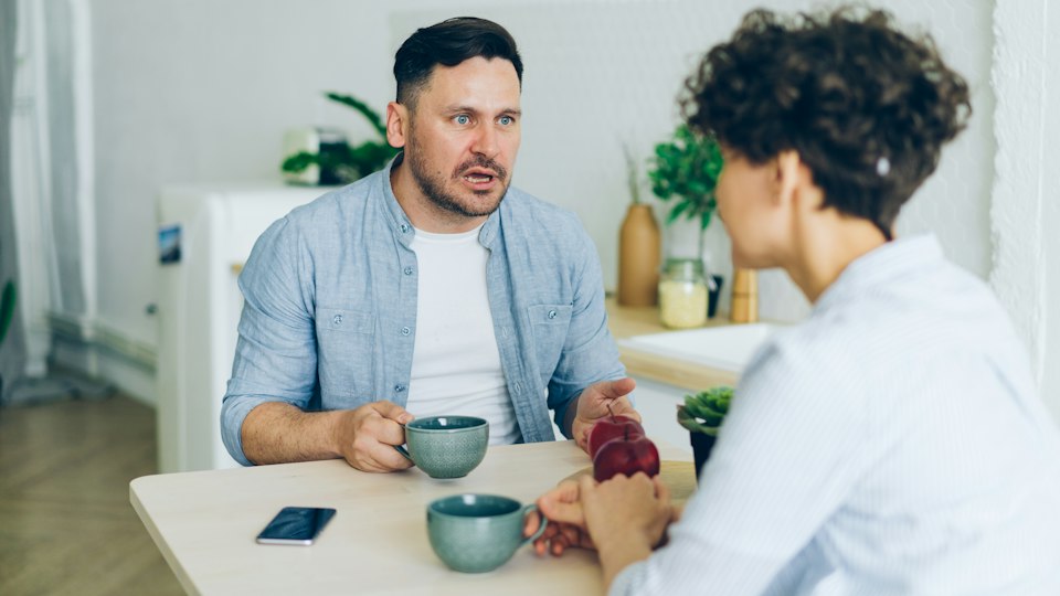 キッチンのテーブルで口論する夫婦